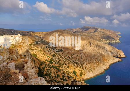 Folegandros: Elevated view of Chora town, cliffs, old terraced slopes and the sea soon after sunrise on Folegandros Island, Cyclades, Greece Stock Photo