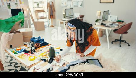 Fashion designer, woman and sketch at desk for planning clothing design and choosing fabric for product sample. Small business, entrepreneur and draft Stock Photo