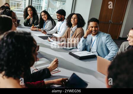 Professionals gathered in a seminar setting engaging in collaborative discussion. The diverse group conveys teamwork and creativity during the busines Stock Photo