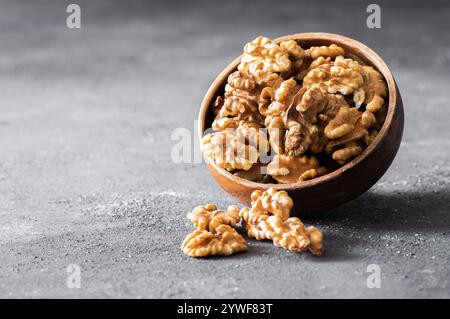 Ripe and fresh walnut kernels in bowl or burlap sack without shell on rustic table, healthy nut food for brain Stock Photo