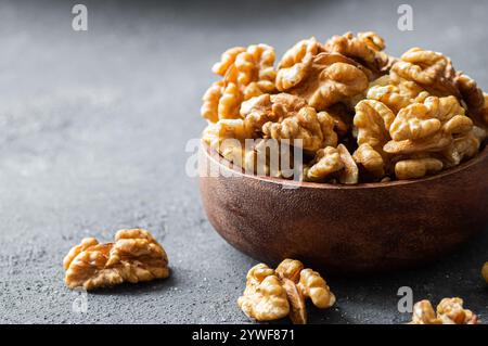 Ripe and fresh walnut kernels in bowl or burlap sack without shell on rustic table, healthy nut food for brain Stock Photo