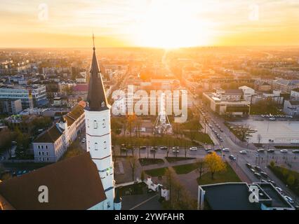 Aerial panorama Siauliai sun city in Lithuania in sunny autumn day on sunset with cityscape and square view. Siauliai Saint Disciple Peter and Paul Ca Stock Photo