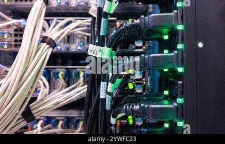 Network server cables and connections illuminated in data center at night Stock Photo