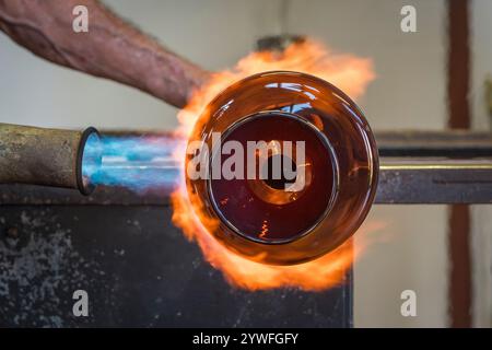 Glassblowing - using a blowtorch to work on a blown glass vase (UK) Stock Photo