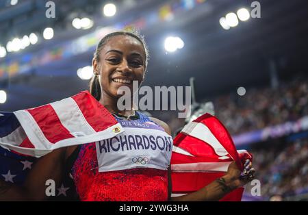 Sha'Carri Richardson celebrating her medal with her country's flag at the Paris 2024 Olympic Games. Stock Photo