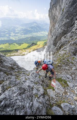 Two mountaineers with helmets on a narrow hiking trail, ascent to the Ackerlspitze, Wilder Kaiser, Kaiser Mountains, Tyrol, Austria, Europe Stock Photo