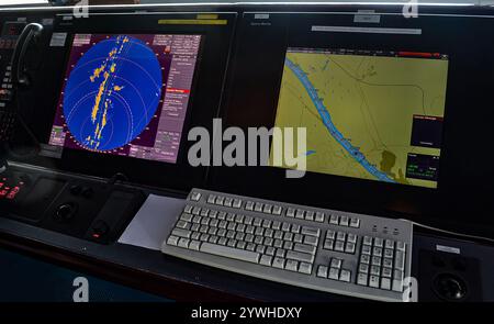 Ship's bridge with navigation control panel displaying radar and gps data, ensuring safe passage through waterways Stock Photo