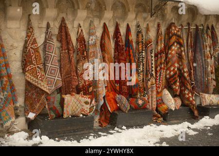 Göreme, Cappadocia, Türkiye - December 1, 2024 :Stunning colorful  traditional Turkish handmade knitted carpets hanging on the walls during winter Stock Photo