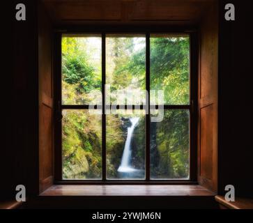 A shot taken from inside the Grot at Rydal Hall Lake District Cumbria. A window view with a waterfall. Stock Photo