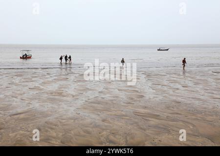 BAKO NATIONAL PARK, MALAYSIA - MARCH 9, 2024: Tourists arrive by boats on the beach in Bako National Park in Sarawak state of Borneo island, Malaysia. Stock Photo