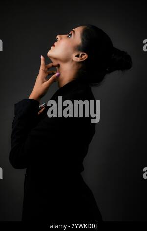 A stunning solo image of a tall female model in a classic black suit. The sleek lines and polished look emphasize the elegance, beauty, and versatilit Stock Photo