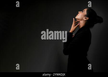 A stunning solo image of a tall female model in a classic black suit. The sleek lines and polished look emphasize the elegance, beauty, and versatilit Stock Photo