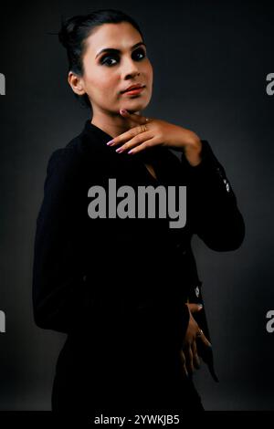 A stunning solo image of a tall female model in a classic black suit. The sleek lines and polished look emphasize the elegance, beauty, and versatilit Stock Photo