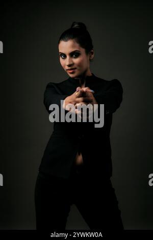 A stunning solo image of a tall female model in a classic black suit. The sleek lines and polished look emphasize the elegance, beauty, and versatilit Stock Photo