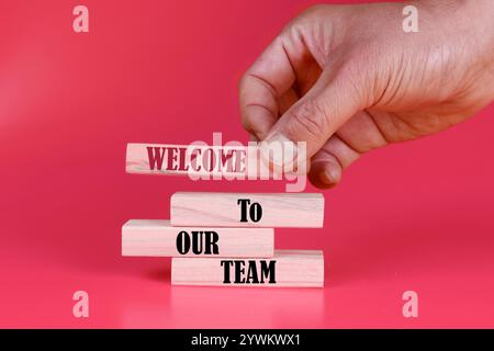 Welcome to our team symbol. Concept words Welcome to our team on wooden blocks. Beautiful deep pink background. Business and Welcome to our team conce Stock Photo