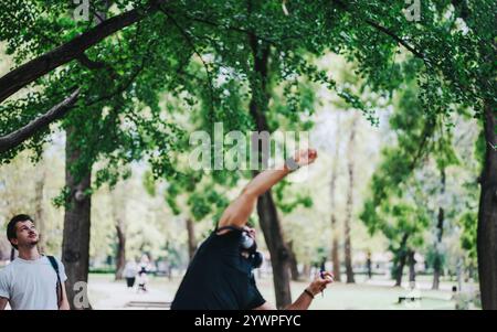 Students collaborating on school projects under the trees in the park Stock Photo