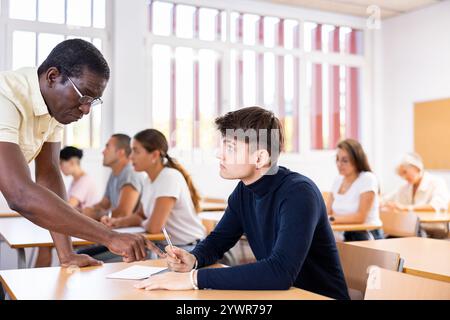 African American teacher helping student solve task during lesson Stock Photo