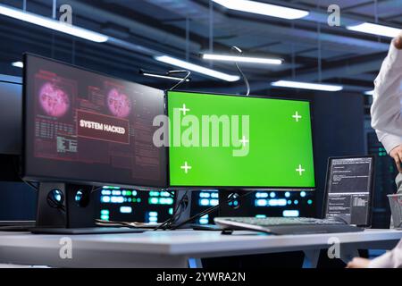 Admin using isolated screen PC in server farm trying to protect hardware from hacker attack stealing sensitive information. Data center employee seeing security breach alert on chroma key monitor Stock Photo
