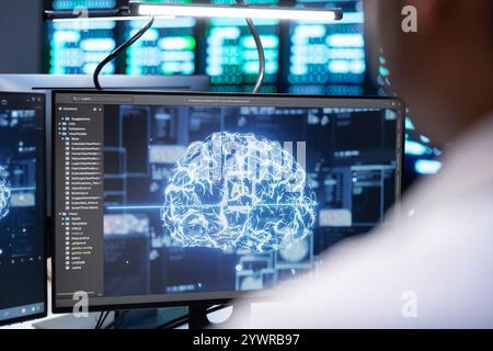 Engineer using AI tech on computer to do checkup in server farm providing storage. IT expert using PC to enable artificial intelligence to process datasets for training and inference Stock Photo