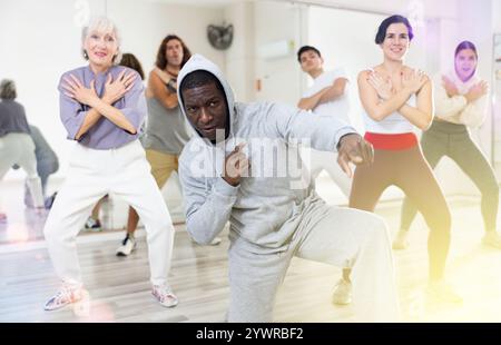 African-american man rehearsing modern hip-hop with group in dance school Stock Photo