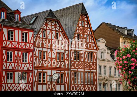 Historic half-timbered houses with intricate painted wooden beams and decorative facades line a street in Trier, Germany Stock Photo