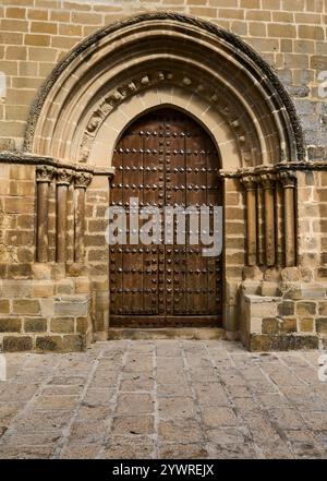 A beautifully crafted medieval-style wooden door set in a historic stone archway, showcasing detailed architecture and classic craftsmanship. Stock Photo