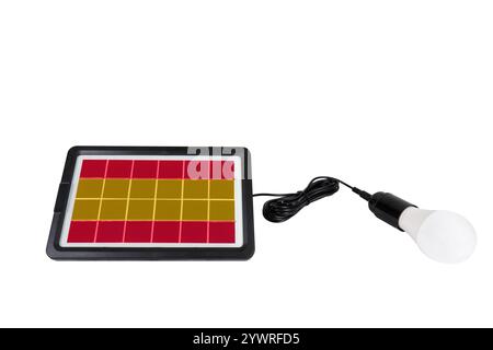 Portable solar panel in the shape of the flag of Spain connected to a light bulb isolated on white background (close-up) Stock Photo