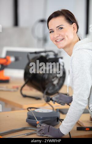 female engineer or tech repairs electronic device Stock Photo