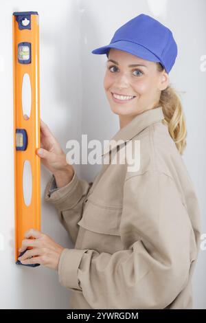 female builder using a spirit level Stock Photo