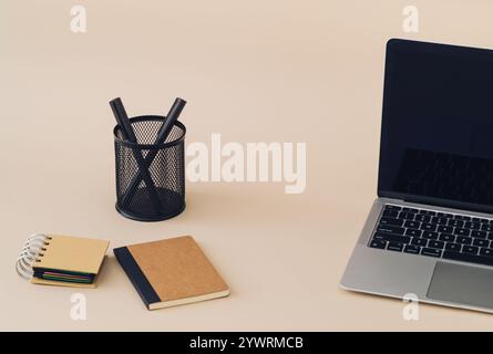 Trendy layout made with computer, notebooks and pens on beige background. Minimal business concept. Creative office objects idea backdrop. Stock Photo