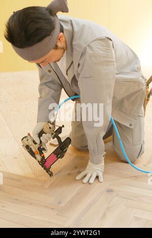 Carpenter's man applying floor coverings Stock Photo