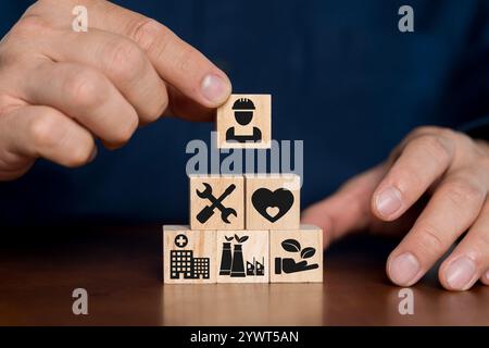 Health safety environment HSE education industry Concept, Man hand holding wooden cube block with Health safety environment icon with copy space. Stock Photo