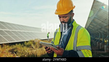 Solar panel, outdoor and man with tablet, engineering and thinking with online reading. Inspector, employee and professional in field, technology or Stock Photo