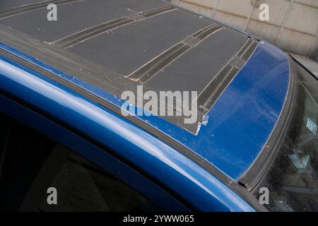 Cremona, Italy - November 27th 2024 Close-up of damaged panoramic sunroof of blue toyota sienna minivan temporarily repaired using duct tape Stock Photo