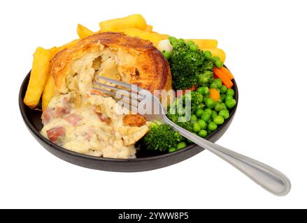Creamy chicken, ham and leek pie meal with chips and mixed vegetables isolated on a white background Stock Photo