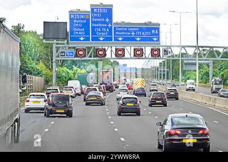 M25 five lane busy motorway at junction 4B gantry destination signs above 40mph electronic variable speed limit  in Friday rush hour South London UK Stock Photo