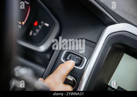 Start stop engine button, car driver starting the car Stock Photo
