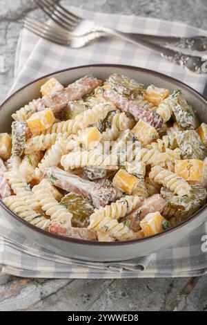 Pickle Pasta Salad with cheddar cheese, dill and bacon seasoned with cream sauce close-up in bowl on table. Vertical Stock Photo