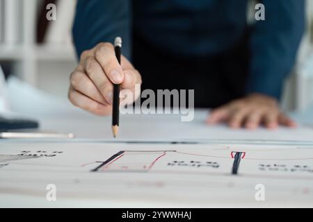 Engineer analyzing architectural blueprint in modern office environment for effective design solutions Stock Photo