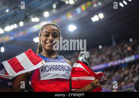 Sha'Carri Richardson celebrating her medal with her country's flag at the Paris 2024 Olympic Games. Stock Photo