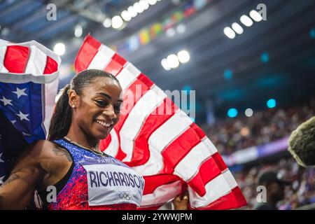 Sha'Carri Richardson celebrating her medal with her country's flag at the Paris 2024 Olympic Games. Stock Photo