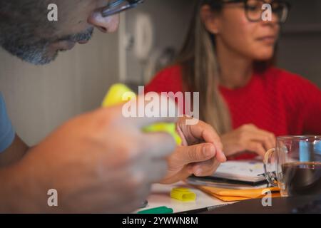 The woman is typing on a laptop while the man is holding a yellow object. New home concept. Stock Photo