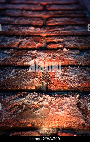 A brick wall in the snow is illuminated from below. Christmas background Stock Photo