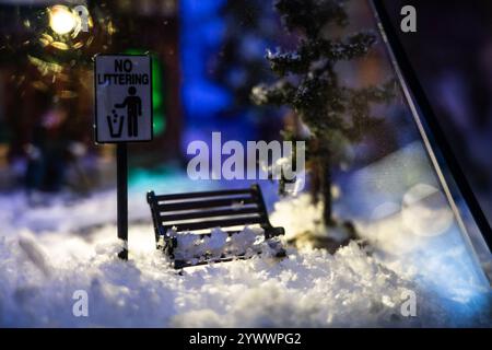 A Christmas diorama. A snow-covered bench under a street lamp Stock Photo