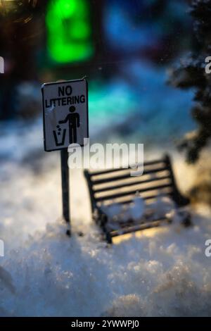 A Christmas diorama. A snow-covered bench under a street lamp Stock Photo