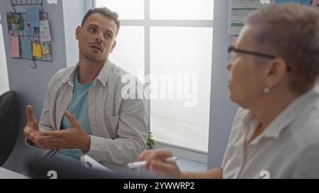 Man and woman discussing seriously in an office, showcasing a professional business interaction between coworkers in a workplace environment Stock Photo