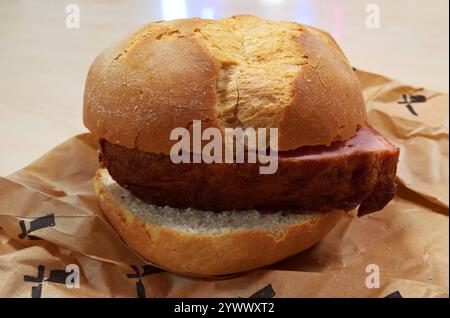Als Fleischkäse, Leberkäse oder Fleischlaib bezeichnet man eine gebackene Brühwurstsorte. Charakteristisch ist die rechteckige Pastetenform. Die Bezeichnung als Käse leitet sich lediglich von der Form der Laibe ab. In Deutschland muss Leberkäse aus Verbraucherschutzgründen Leber enthalten, es sei denn der Name Fleischkäse oder bayrischer Leberkäse wird verwendet. Dies kommt bei einem Grossteil der Zubereitungen vor. Foto: Leberkäs auf einer Semmel bzw einem Brötchen *** Meatloaf, Leberkäse or Fleischlaib is the name given to a baked type of cooked sausage characterized by its rectangular pâté Stock Photo