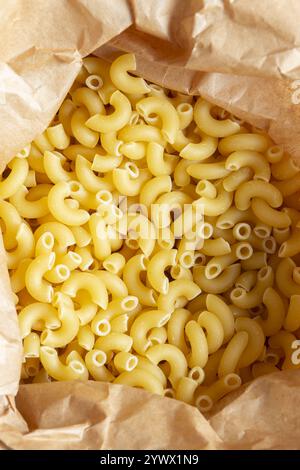 Macaroni dried pasta in a brown paper bag. Eco-friendly  recycling compostable packaging Stock Photo