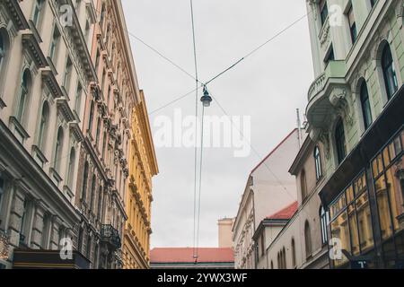 Vienna, Austria - May 12, 2019: A historic street in the old town, featuring colorful buildings with wires and sky between them. The charming urban Stock Photo