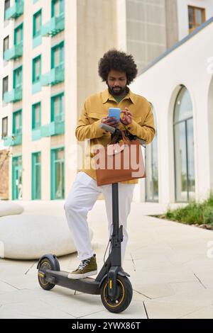Man Using Smartphone While Standing on Electric Scooter Stock Photo